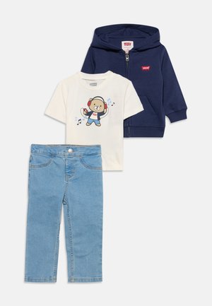 Sweat à capuche zippé bleu marine, t-shirt blanc avec imprimé d'ours portant un casque audio, et jean en denim bleu clair pour enfants.