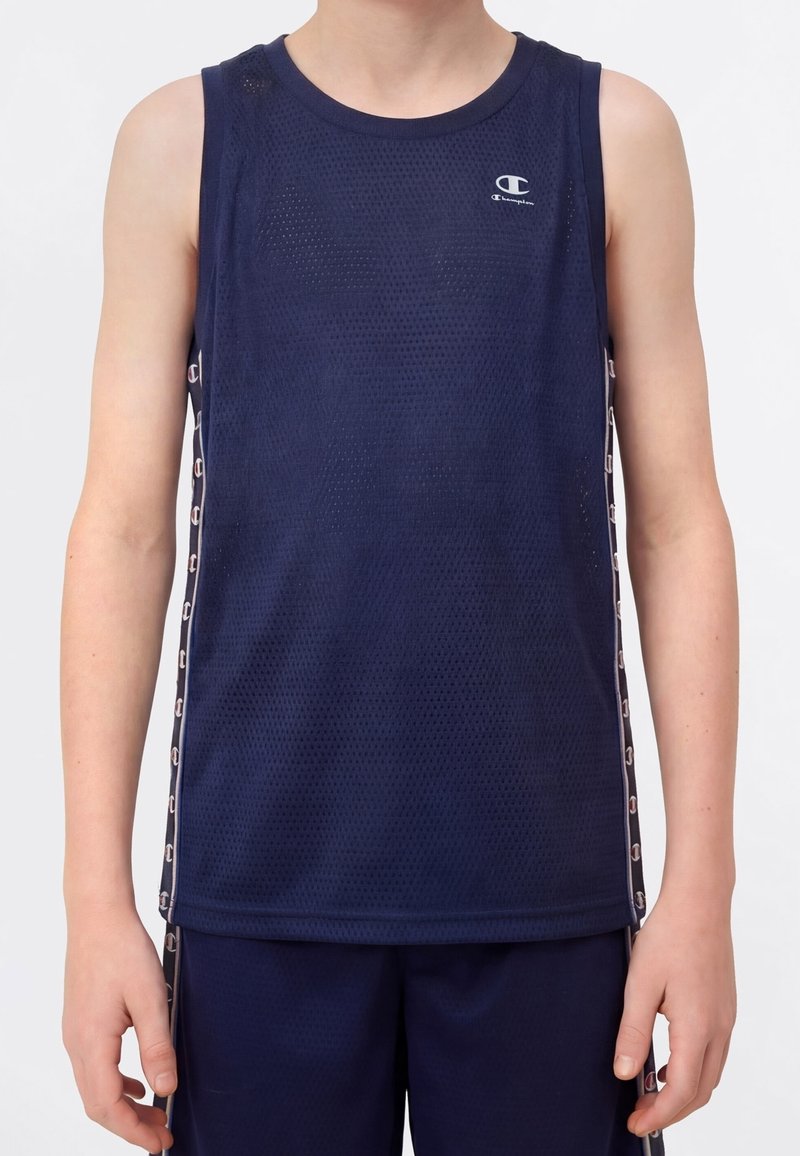Personne portant un maillot de sport sans manches en mesh bleu marine avec le logo Champion sur la poitrine et un short bleu marine assorti.