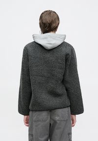 Σκούρα γκρι ζακέτα fleece με υφή και κολλημένη γκρι κουκούλα, με φαρδιά εφαρμογή και πέσιμο στους ώμους.