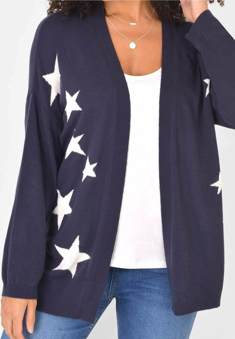 Tmavě modrý kardigan s bílými hvězdnými vzory, otevřený přední design, dlouhé rukávy a žebrované manžety, vyrobený z měkkého pleteného materiálu.