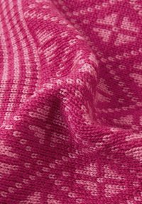 Dziany koc w różnych odcieniach różu. Zawiera fakturowany wzór z naprzemiennymi pasami i geometrycznymi kształtami. Miękki, ciepły materiał.