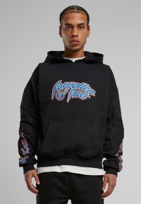Sudadera con capucha negra y bolsillo frontal. Presenta un colorido texto "olvide" y diseños de llamas en las mangas. Tejido suave, corte holgado.