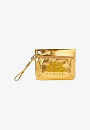 Pochette métallique dorée avec fermeture éclair, poignée, et logo SUNDEK en relief avec un motif de soleil. Texture lisse. Forme rectangulaire.