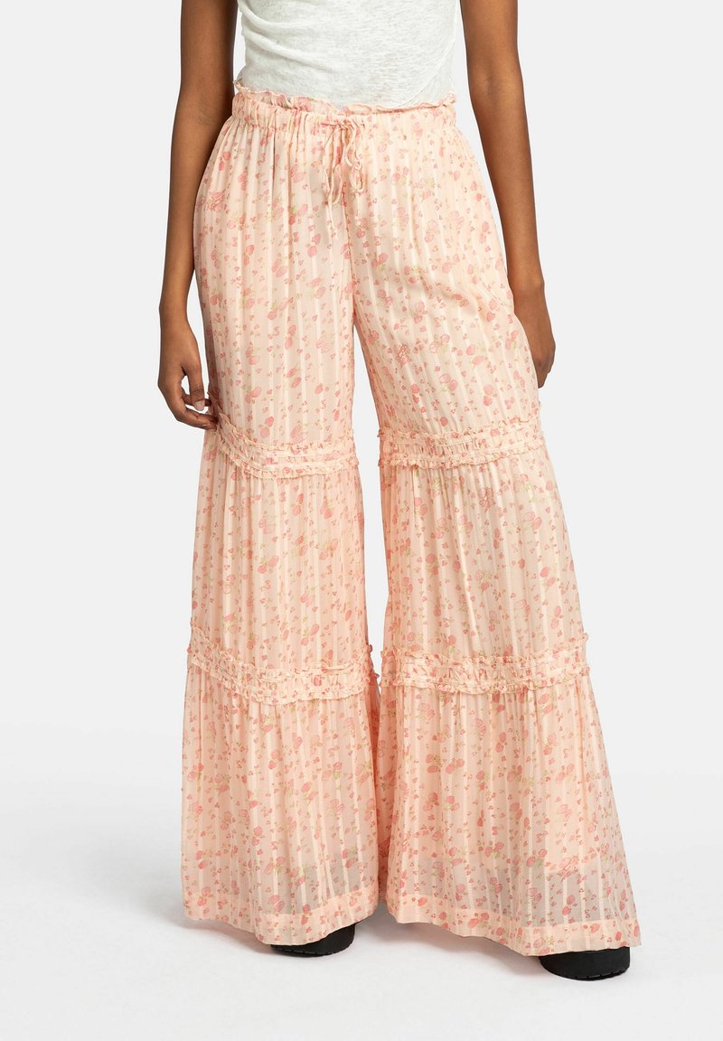 Pantalons à large jambe rose clair avec imprimé floral, accents volantés et taille élastique. Fabriqués en tissu léger et transparent.