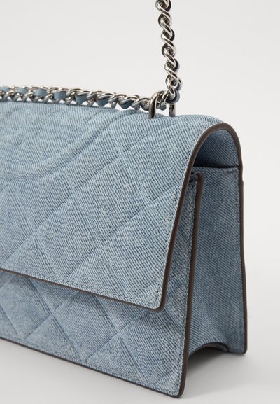 Geantă din denim matlasat în albastru deschis, cu detalii maro. Dispune de o curea din lanț argintie și un design structurat.