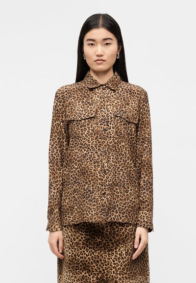 Chemise à manches longues à imprimé léopard en brun et noir, avec deux poches poitrine, fermeture à boutons sur le devant, col, réalisée en tissu lisse.