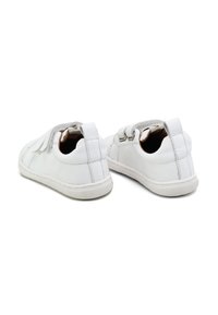 Zapatillas de piel blanca con puntera redondeada, sistema de cordones elásticos y acentos grises contrastantes en la parte superior. Textura suave, suela flexible.