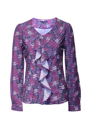 Blusa de manga larga morada con un frente con volantes, que presenta un patrón de formas ovaladas y puntos coloridos en tonos rojos, blancos y verdes.