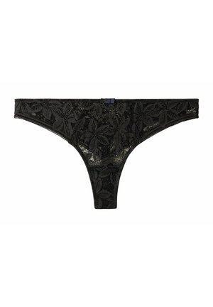 String en dentelle noire avec motif floral, taille élastique et un petit détail de tag. Le tissu présente un design délicat et texturé.
