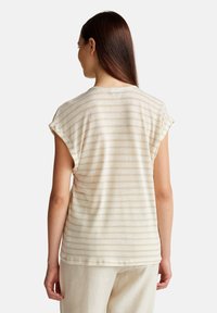 Top corto beige chiaro a maniche corte con sottili righe verticali e una vestibilità rilassata. La texture morbida, il collo arrotondato e le maniche arrotolate arricchiscono il design.