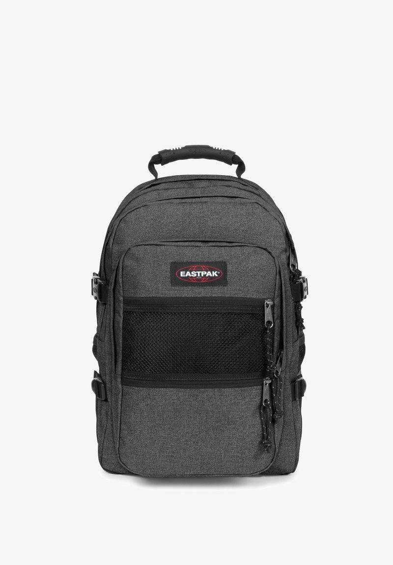 Grå tygryggsäck med ett framskjutande nätfick, dubbla dragkedjor och justerbara remmar. Eastpak-logotypen syns tydligt på framsidan.