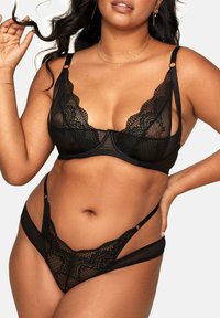 Schwarzes Unterwäsche-Set mit einem Spitzen-Bralette aus durchsichtigem Mesh und verstellbaren Trägern, kombiniert mit einem passenden Spitzen-Thong.