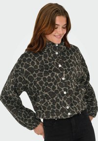 Korte, knoopsluiting jasje in een panterprint met grijze en zwarte tinten. Het heeft een hoge kraag en elastische manchetten.