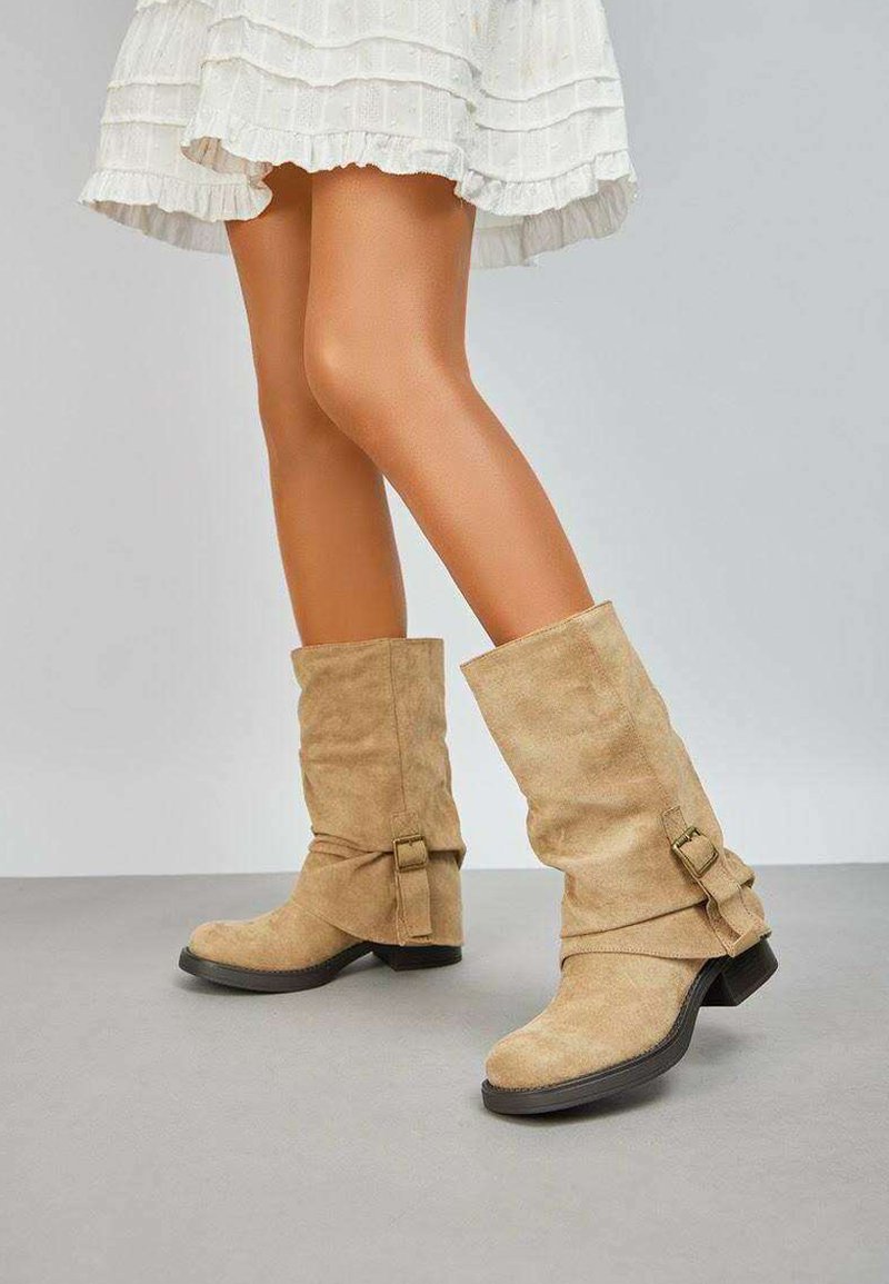 Bottes de cheville en suède beige avec un design flou, dotées de boucles sur les côtés et d'un petit talon épais.