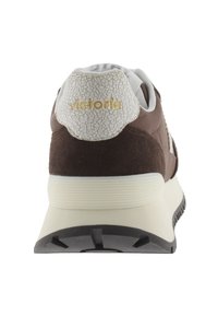 Baskets marron avec une tige en daim, des accents en cuir blanc et craquelé, une languette arrière texturée et une semelle crème avec un motif de traction noir.