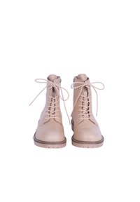 Botas de cuero beige hasta el tobillo con cordones, punta redonda y suelas de goma en contraste. Incluyen un zipper lateral y detalles de costura mínimos.