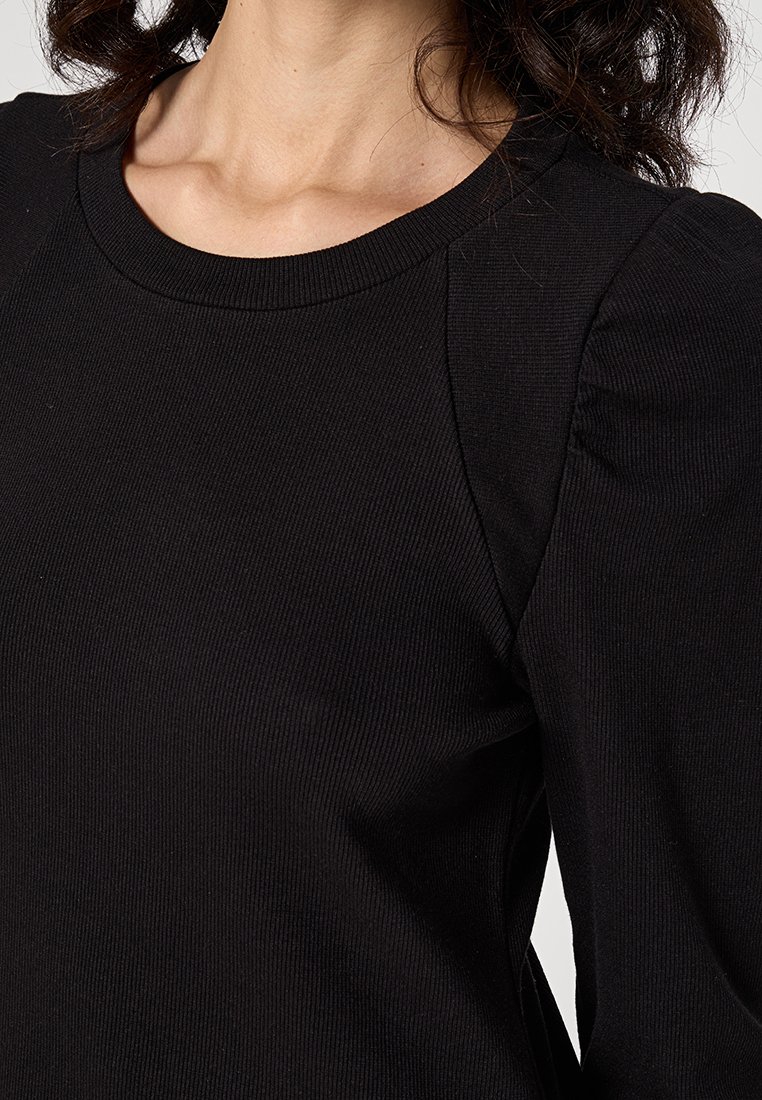 Czarny prążkowany top z okrągłym dekoltem i bufiastymi rękawami. Materiał jest miękki o teksturowanym wyglądzie, oferując dopasowaną sylwetkę.