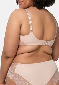 Jasnoróżowy zestaw biustonosza i majtek z koronkowymi dodatkami i regulowanymi ramiączkami, wykonany z miękkiego, gładkiego materiału o bezszwowej konstrukcji.