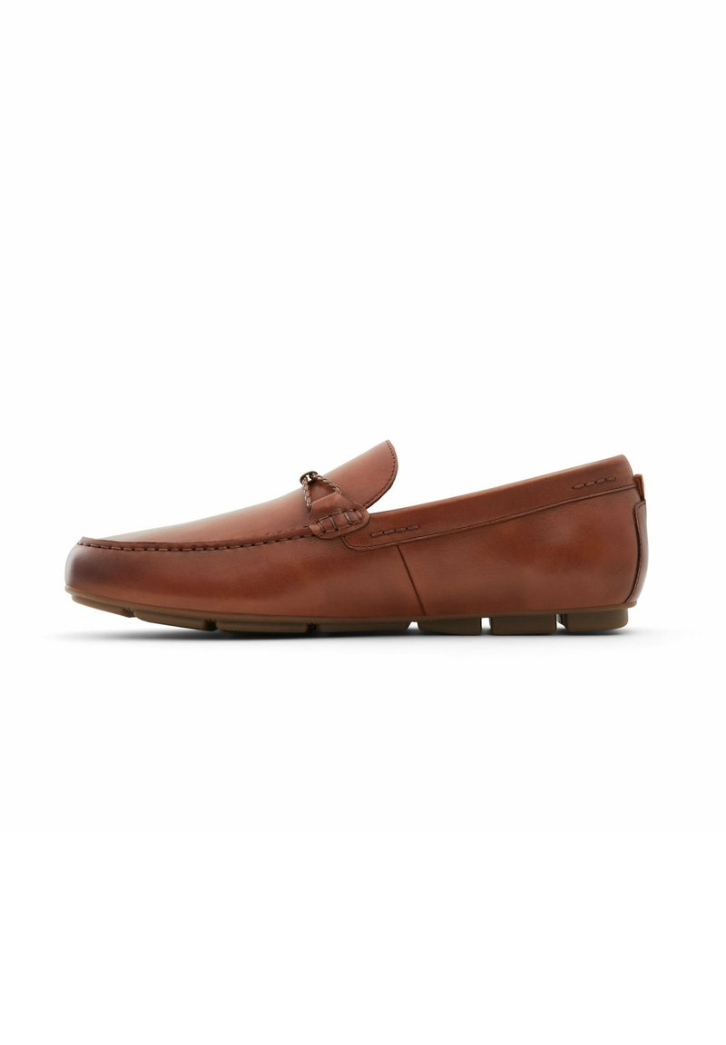 Mocassin homme en cuir marron avec bout moc cousu, ornement métallique décoratif sur le coup de pied et semelle en caoutchouc segmentée pour un usage décontracté.