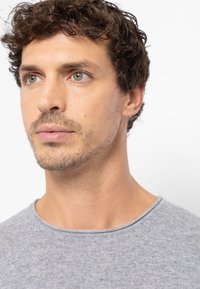 Graues Rundhals-T-Shirt aus weichem, strukturiertem Stoff, mit kurzen Ärmeln und regulärer Passform; schlichtes Design ohne zusätzliche Akzente.