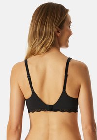 Sort bh med blondekant, justerbare stropper og en hægte- og øje-lukning. Stoffet ser glat ud med en blød tekstur.