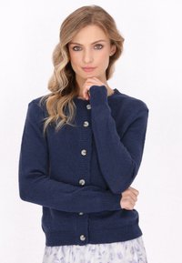 Navy knitted cardigan with long sleeves, button front, and ribbed cuffs. Smooth texture with subtle stitch detailing and silver buttons.