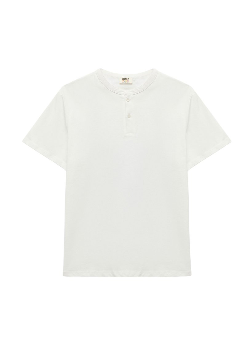 Camiseta blanca de manga corta con escote redondo y tapeta de tres botones. Fabricada con una tela suave de textura lisa, sin patrones ni acentos.