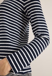 Suéter a rayas azul marino y blancas con un diseño de punto texturizado. Las mangas largas presentan una ligera forma de campana en los puños.