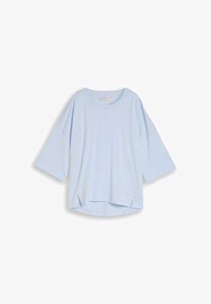 Jasnoniebieski oversize T-shirt z rękawami do łokcia i małymi bocznymi rozcięciami na dole, przedstawiony na białym tle.