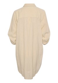 Chemise en lin beige avec col, manches longues et coupe décontractée. Présente un dos plissé et une surface lisse et texturée.