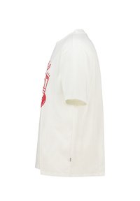 White cotton t-shirt with short sleeves, featuring a red graphic design on the front, showcasing a hand holding a paintbrush.