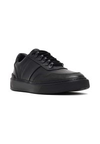 Baskets en cuir noir avec une finition lisse, présentant un bout arrondi, un laçage à l'avant et une semelle en caoutchouc texturé pour l'adhérence.