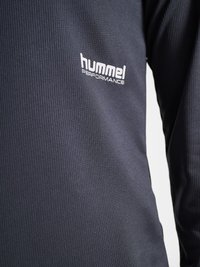 Ciemnoszara tkanina o fakturze z białym logo "hummel PERFORMANCE" nadrukowanym na obszarze klatki piersiowej długorękawowej odzieży.