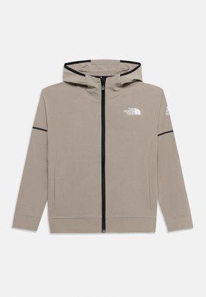 Lysebrun hættejakke med sort lynlås og sorte kanter på ærmerne, med The North Face-logo på brystet og venstre arm.