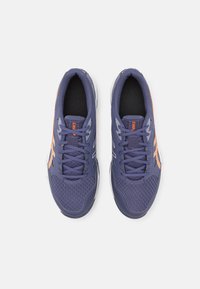 Purple athletic shoes featuring a textured mesh upper, orange accents, and white soles. Six eyelets for laces and padded tongue included.