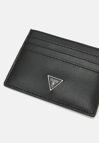 Cardholder din piele texturată neagră, dotat cu trei sloturi pentru carduri, având un emblemă logo triangulară argintie pentru detalii de brand.