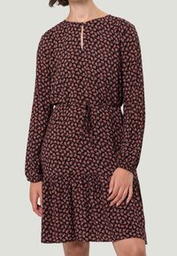 Schwarzes Kleid mit einem kleinen Blumenmuster in Rottönen und Rosa, langen Ärmeln, einem runden Ausschnitt mit einer Schlüssellochdetail und einem Taillengürtel.