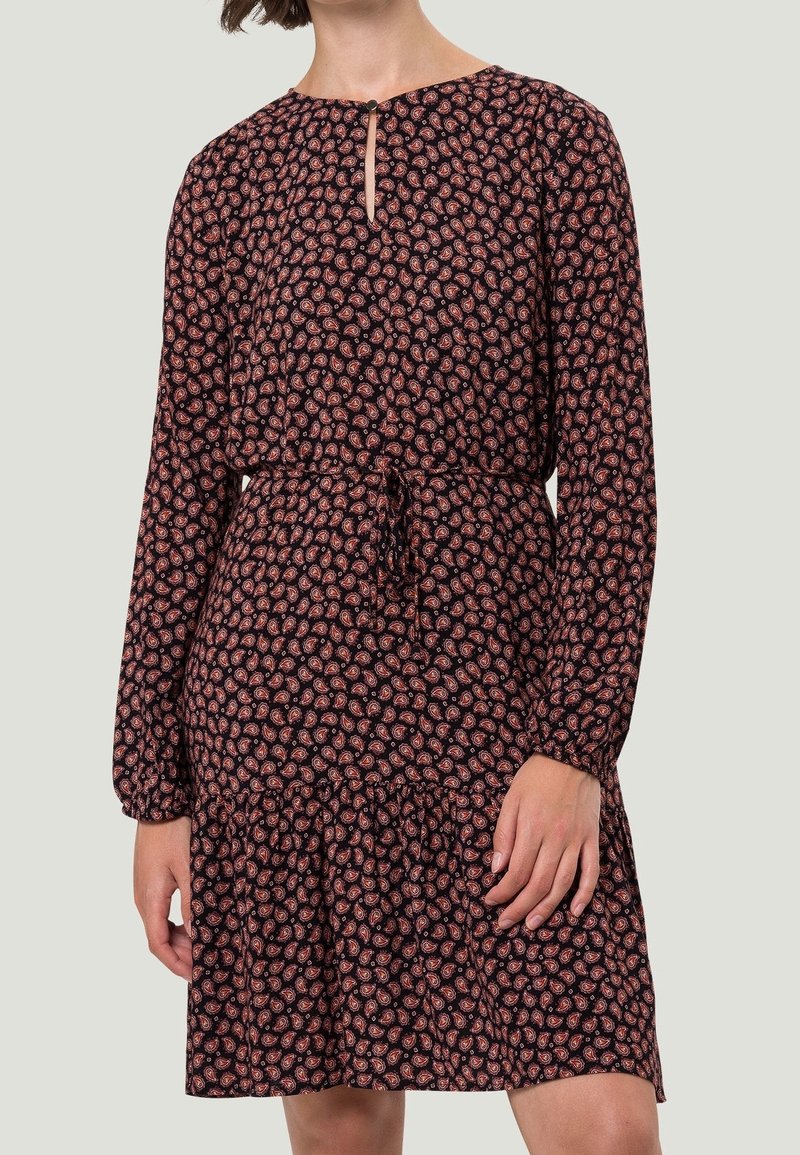 Schwarzes Kleid mit einem kleinen Blumenmuster in Rottönen und Rosa, langen Ärmeln, einem runden Ausschnitt mit einer Schlüssellochdetail und einem Taillengürtel.