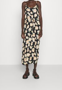 Květinové midi šaty s černým pozadím, ozdobené světlými oranžovými růžemi, s nastavitelnými ramínky a stahovacími šňůrkami v pase. Vyrobené z měkké tkaniny.