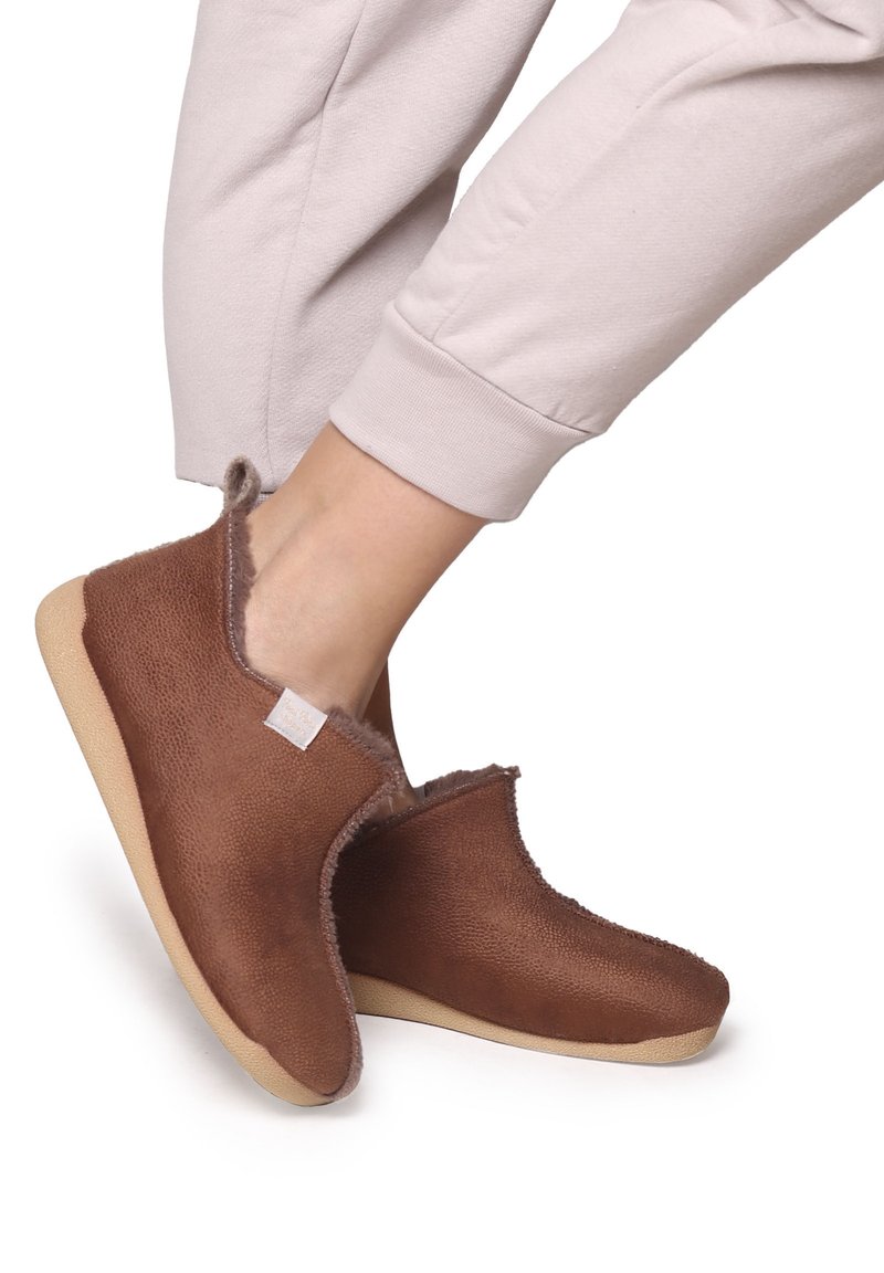 Bruna, texturerade tofflor med en mjuk foder, rund tå, flexibel sula och minimal sömnadsdetalj. Bärs med ljusa byxor.