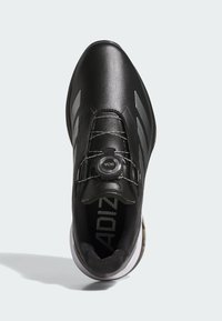 Black sports shoe with gray stripes, featuring a dial lace system and white sole, viewed from above on light gray background.