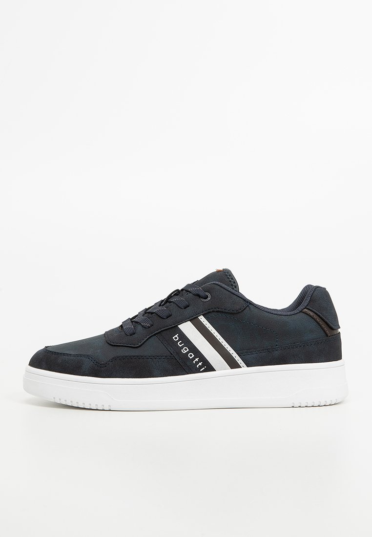 Zapatilla de ante azul marino con suela de goma blanca, con acentos oscuros y tres rayas horizontales en blanco y negro en el lateral.