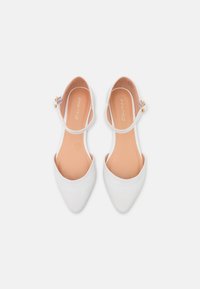 Białe baleriny z ostrym noskiem, wykonane z teksturowanego materiału syntetycznego, z tylnym paskiem ze złotym zapięciem oraz gładką cielistą wkładką.