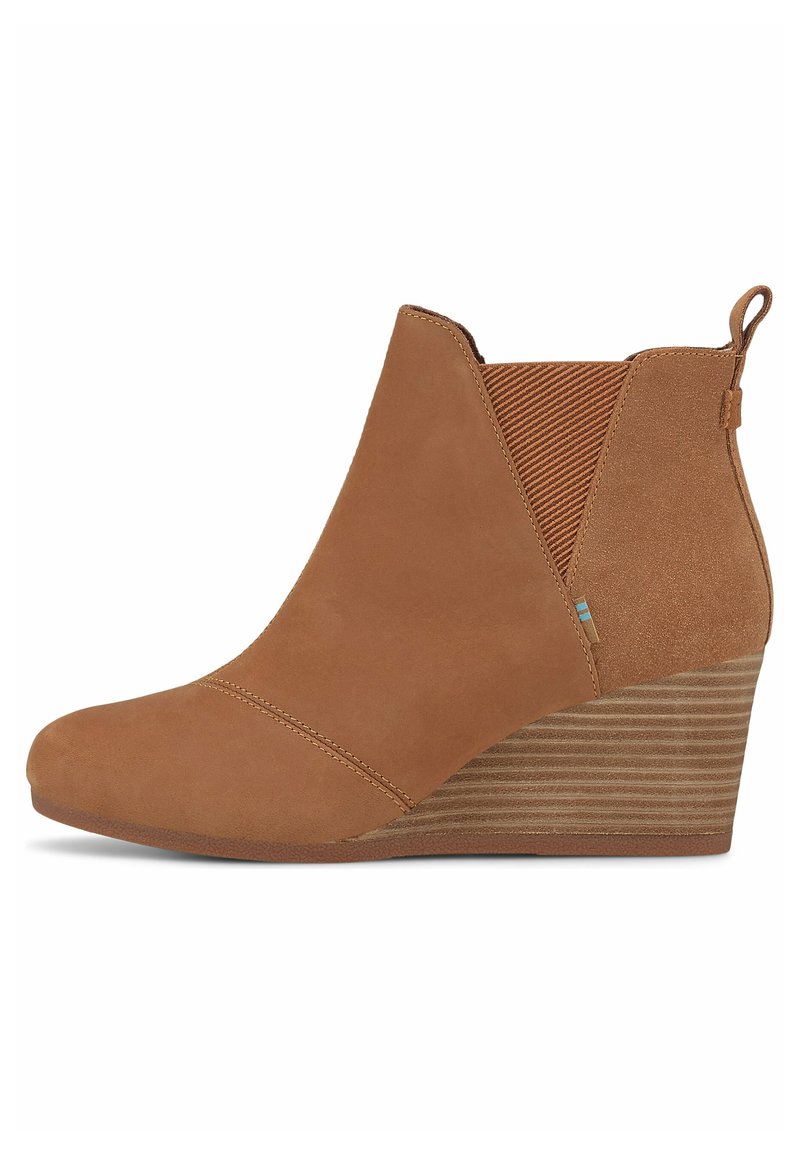 Botín de ante marrón con tacón cuña, panel lateral elástico, costuras contrastantes y un tacón texturizado y a rayas.