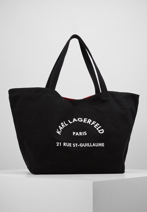 Czarna torba na ramię z podwójnymi uchwytami, z przodu nadrukowany biały tekst "Karl Lagerfeld Paris 21 Rue St-Guillaume", widoczna czerwona podszewka.