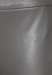 Grå konstläder med en strukturerad yta, som visar en subtil lyster och fint kornmönster. Inga synliga beslag eller detaljer.