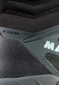 Črne pohodniške čevlje z strukturirano zgornjimi deli, oznako GORE-TEX in gumijastimi detajli. Vključujejo mrežaste panele in trpežen podplat.