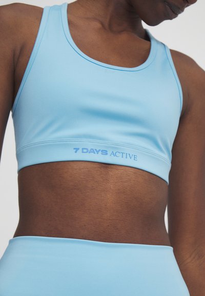 Jasnoniebieski biustonosz sportowy, wykonany z elastycznego materiału, z okrągłym dekoltem i napisem "7 DAYS ACTIVE" na pasku.