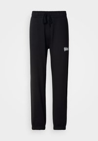 Schwarze Sweatpants aus weichem Stoff, mit einem elastischen Taillenbund und verstellbaren Kordeln sowie einem kleinen gestickten Logo an der Seite.