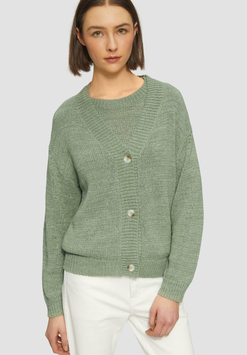 Cardigan vert clair en maille texturée, présentant un col en V, une fermeture à boutons et une coupe décontractée avec des accents côtelés.